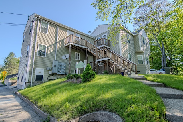 view of side of property featuring stairway and a balcony