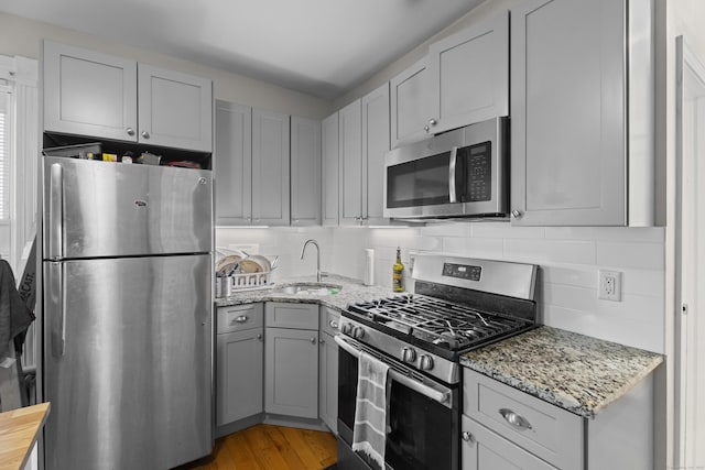 52 Edwards St, New Haven, CT 06511 - kitchen featuring appliances with stainless steel finishes, a sink, gray cabinetry, light stone counters, and backsplash