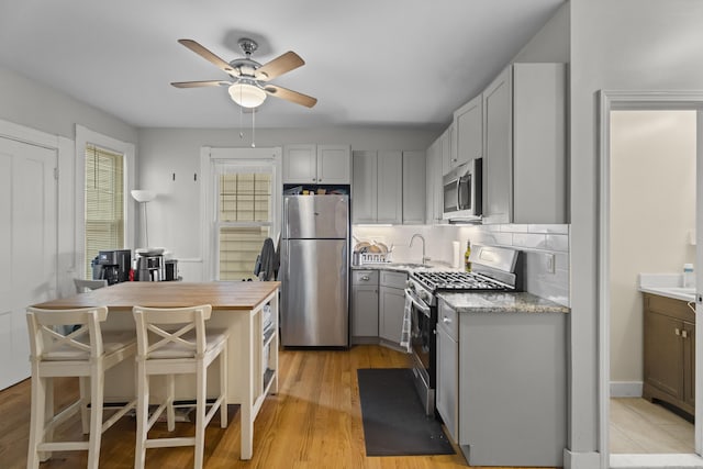 52 Edwards St, New Haven, CT 06511 - kitchen featuring stainless steel appliances, a sink, ceiling fan, gray cabinetry, and decorative backsplash
