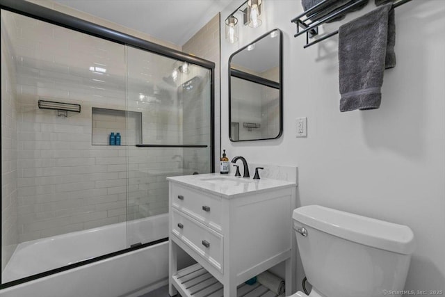 bathroom featuring toilet, enclosed tub / shower combo, and vanity