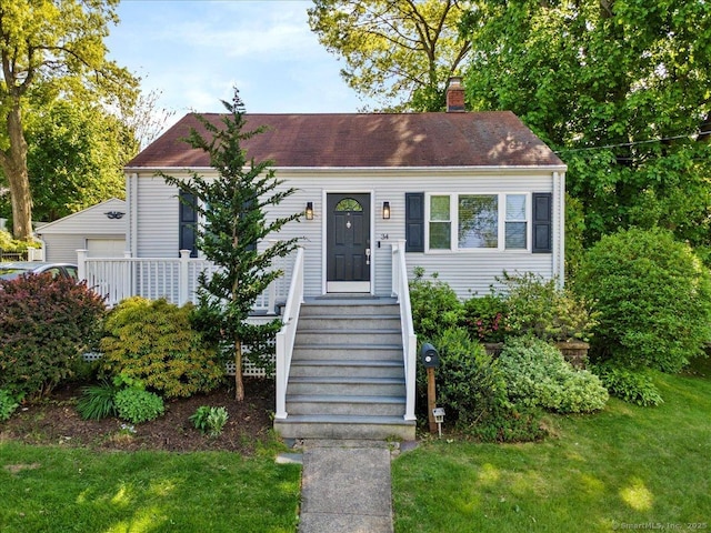 view of front facade with a front lawn, a chimney, and a garage