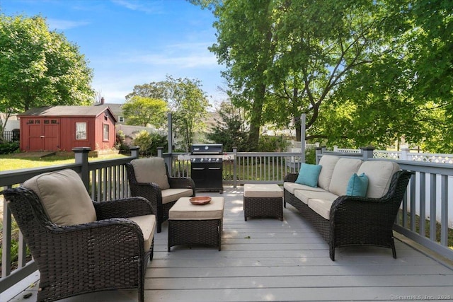 deck with an outdoor living space, a grill, a storage unit, and an outbuilding