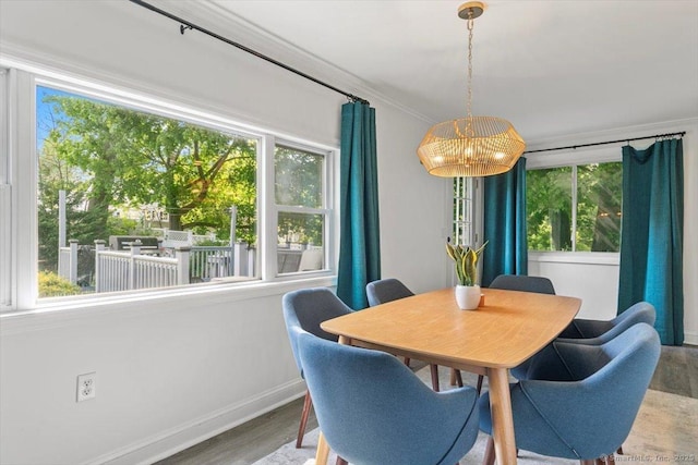 dining area with plenty of natural light, ornamental molding, baseboards, and wood finished floors