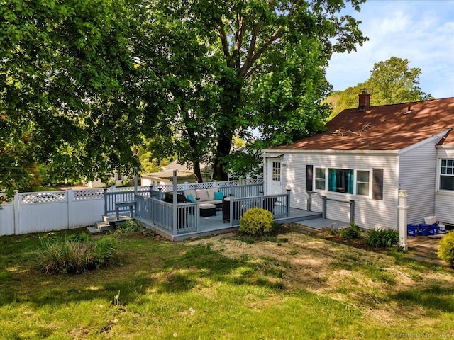 back of property with outdoor lounge area, a deck, and a chimney