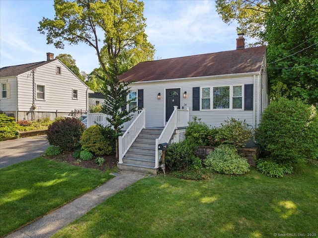 view of front of property with a chimney and a front yard