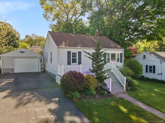 view of front of property with a chimney, an outbuilding, a garage, a front lawn, and asphalt driveway