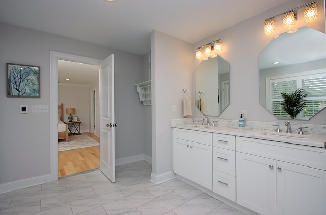 229 Long Hill Cross Rd, Shelton, CT 06484 - ensuite bathroom featuring marble look tiles, double vanity, baseboards, and recessed lighting