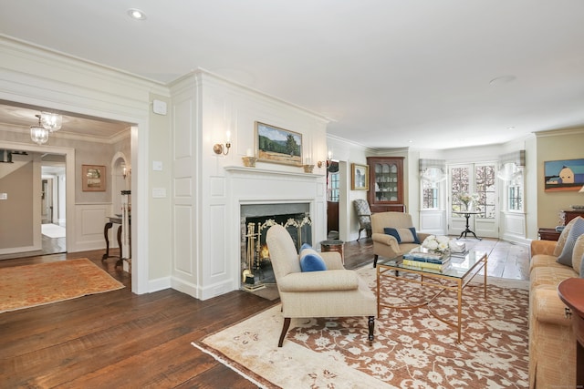 1191 Oenoke Rdg, New Canaan, CT 06840 - living area with dark wood-style floors, ornamental molding, a decorative wall, a fireplace, and recessed lighting