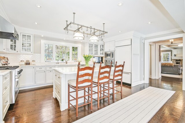 1191 Oenoke Rdg, New Canaan, CT 06840 - kitchen with built in appliances, light countertops, decorative backsplash, a breakfast bar area, and white cabinets