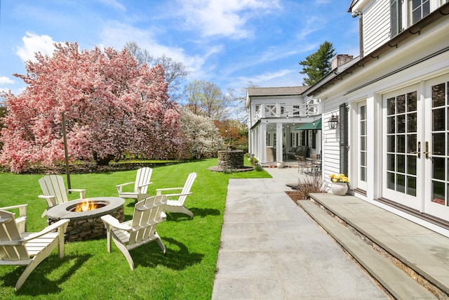 1191 Oenoke Rdg, New Canaan, CT 06840 - view of grassy yard featuring an outdoor fire pit, a patio area, and french doors