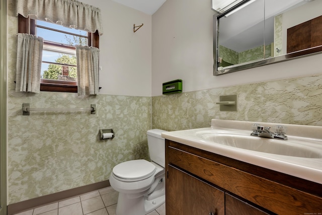 bathroom with tile patterned flooring, toilet, a wainscoted wall, and vanity