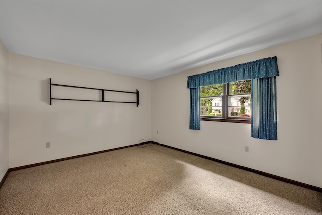 carpeted empty room with baseboards