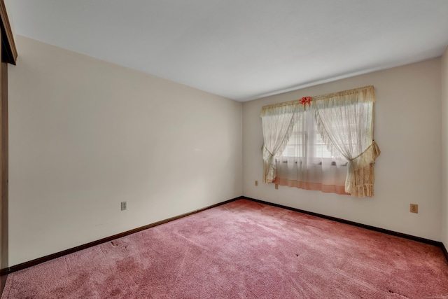 empty room featuring carpet flooring and baseboards