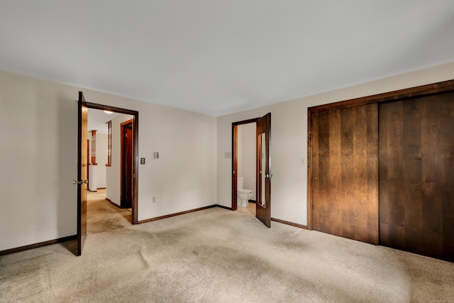 unfurnished bedroom with light colored carpet, baseboards, and a closet