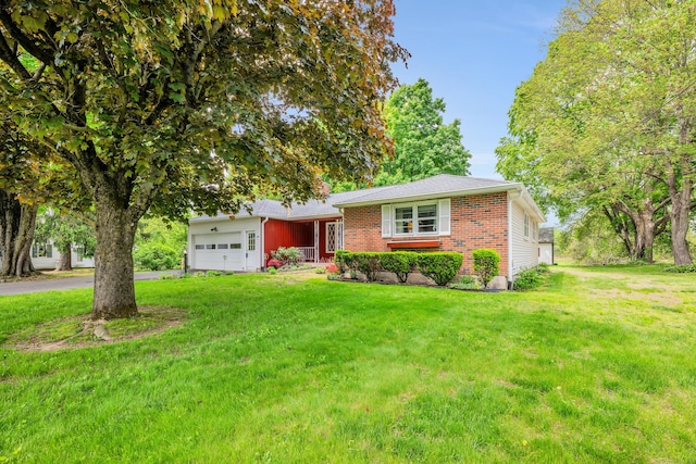 view of front of house with an attached garage, a front lawn, brick siding, and asphalt driveway