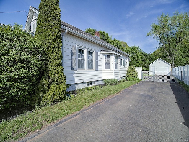 283 Quinnipiac Ave, North Haven, CT 06473 - view of property exterior featuring a chimney, fence, a detached garage, asphalt driveway, and an outbuilding