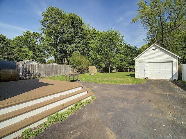283 Quinnipiac Ave, North Haven, CT 06473 - view of yard featuring a garage, an outbuilding, a wooden deck, driveway, and view of wooded area
