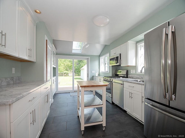 283 Quinnipiac Ave, North Haven, CT 06473 - kitchen with stainless steel appliances, white cabinetry, lofted ceiling, a sink, and recessed lighting