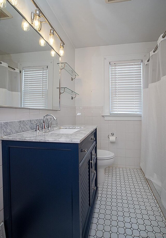 283 Quinnipiac Ave, North Haven, CT 06473 - full bath with vanity, tile walls, toilet, wainscoting, and a shower with curtain