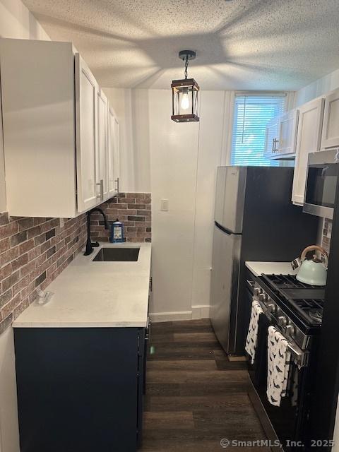 36 Bellevue Ave, Bristol, CT 06010 - kitchen featuring gas stove, a sink, stainless steel microwave, dark wood-type flooring, and light countertops