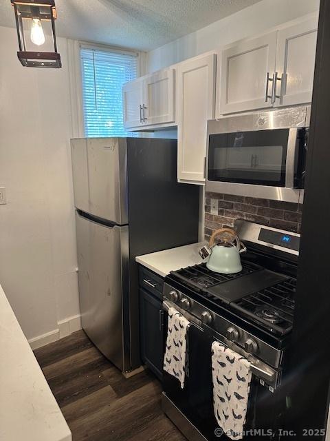 36 Bellevue Ave, Bristol, CT 06010 - kitchen with stainless steel appliances, dark wood finished floors, light countertops, decorative backsplash, and a textured ceiling