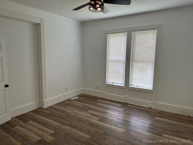36 Bellevue Ave, Bristol, CT 06010 - unfurnished bedroom featuring multiple windows, dark wood finished floors, and baseboards