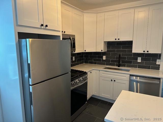 36 Bellevue Ave, Bristol, CT 06010 - kitchen featuring stainless steel appliances, a sink, light countertops, and white cabinetry