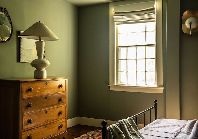 bedroom featuring multiple windows, dark wood-style flooring, and baseboards