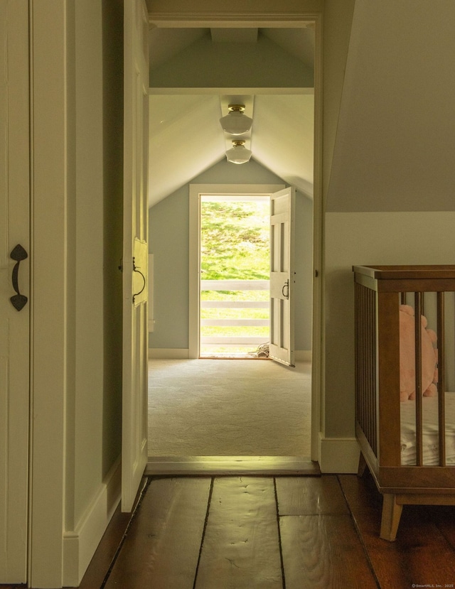 corridor with vaulted ceiling and carpet floors