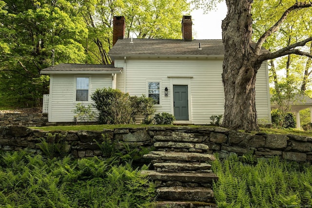 back of house featuring a chimney