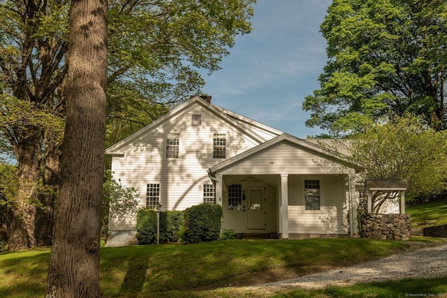 view of front facade with a front yard and a chimney
