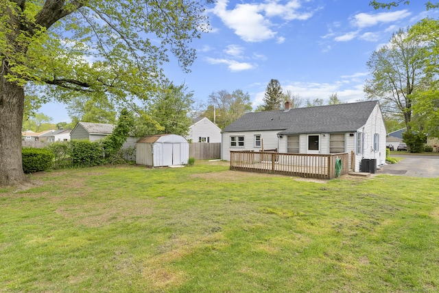 81 Montague Cir E, Hartford, CT 06118 - back of property with a storage unit, a chimney, a wooden deck, an outdoor structure, and roof with shingles