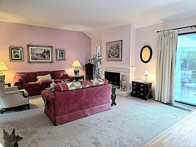 470 Heritage Vlg Unit A, Southbury, CT 06488 - living room featuring a fireplace with raised hearth, vaulted ceiling, and wood finished floors