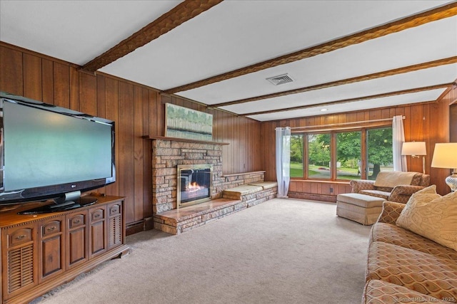 120 Peters Ln, Stratford, CT 06614 - living room with beamed ceiling, wood walls, light carpet, and a stone fireplace