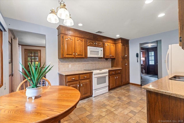 120 Peters Ln, Stratford, CT 06614 - kitchen with white appliances, tasteful backsplash, stone tile floors, recessed lighting, and brown cabinets