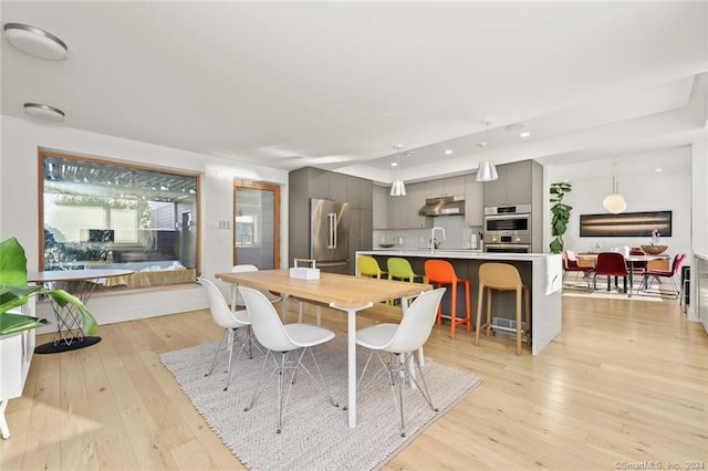 dining room with light wood-style floors and recessed lighting