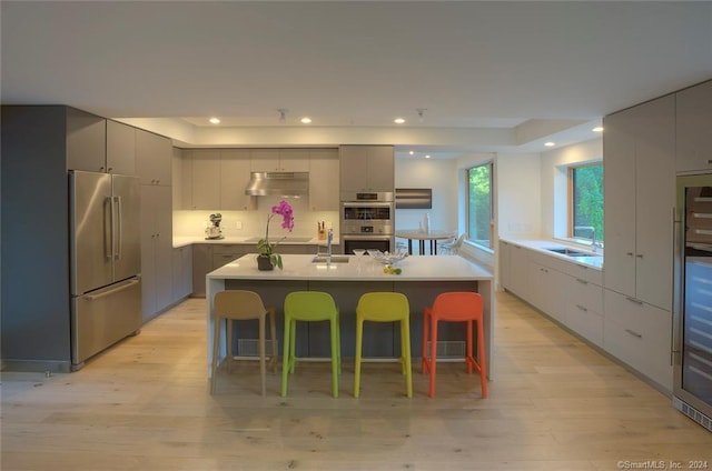 kitchen featuring appliances with stainless steel finishes, modern cabinets, a sink, under cabinet range hood, and recessed lighting