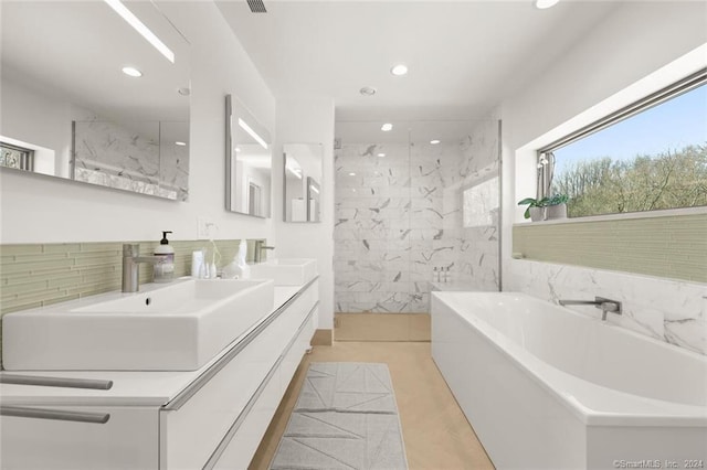full bathroom with recessed lighting, a marble finish shower, a bath, and double vanity
