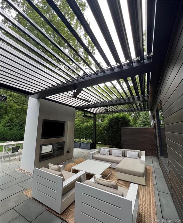 view of patio featuring an outdoor living space with a fireplace and a pergola