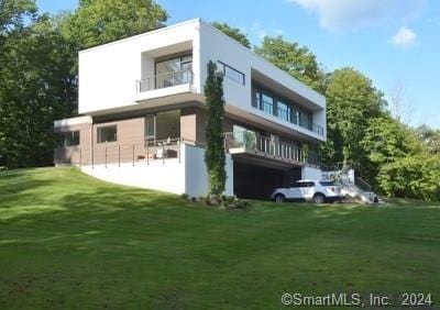 back of house featuring a lawn and stucco siding