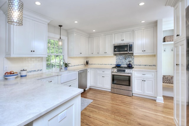 127 College Park Dr, Fairfield, CT 06824 - kitchen featuring stainless steel appliances, a sink, white cabinets, light wood-style flooring, and recessed lighting