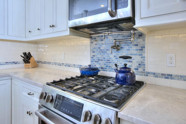 127 College Park Dr, Fairfield, CT 06824 - kitchen with appliances with stainless steel finishes, white cabinetry, tasteful backsplash, and light stone countertops