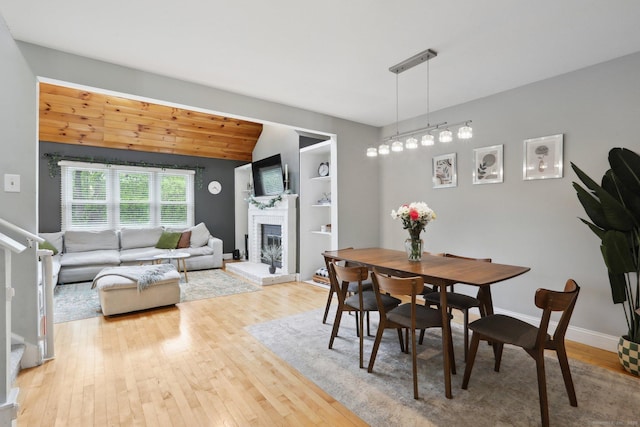 36 Overlook Dr Unit 36, Monroe, CT 06468 - dining area with hardwood / wood-style floors, a brick fireplace, built in features, lofted ceiling, and baseboards