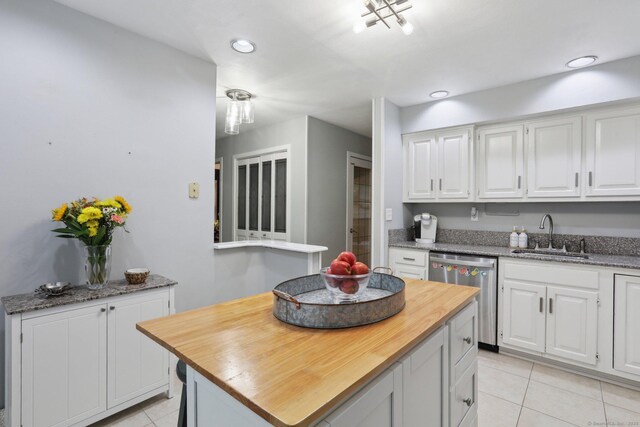 36 Overlook Dr Unit 36, Monroe, CT 06468 - kitchen featuring a sink, stainless steel dishwasher, wooden counters, light tile patterned floors, and white cabinets