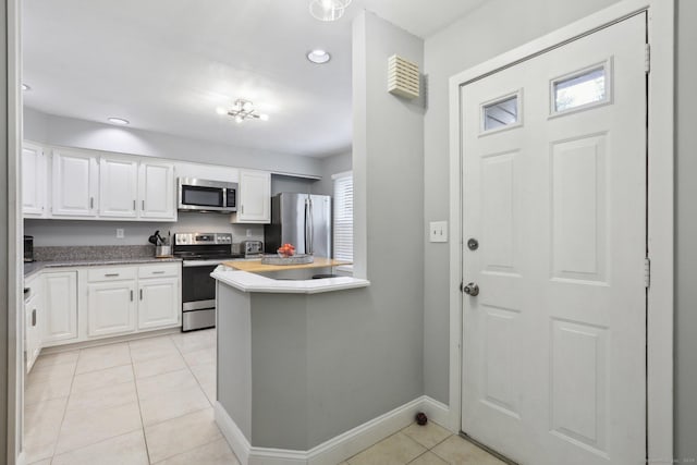 36 Overlook Dr Unit 36, Monroe, CT 06468 - kitchen featuring stainless steel appliances, light tile patterned flooring, white cabinets, baseboards, and a peninsula