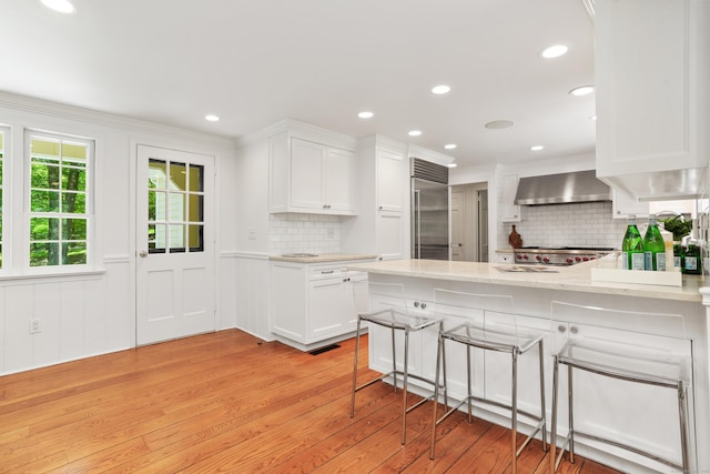 26 Heritage Ln, Weston, CT 06883 - kitchen featuring stainless steel built in refrigerator, wall chimney range hood, light wood-type flooring, backsplash, and recessed lighting