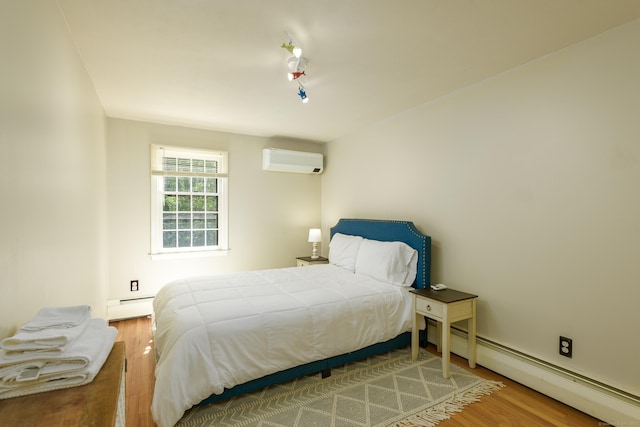 15 Haywardville Rd, East Haddam, CT 06423 - bedroom featuring an AC wall unit, baseboard heating, wood finished floors, and rail lighting