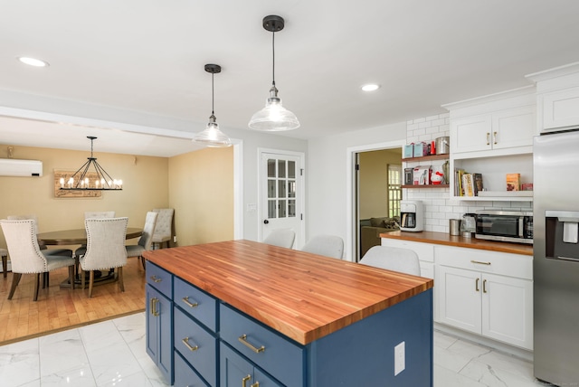 15 Haywardville Rd, East Haddam, CT 06423 - kitchen with wooden counters, stainless steel appliances, light marble finish floors, an AC wall unit, and blue cabinets