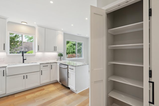 787 Heritage Vlg Unit A, Southbury, CT 06488 - kitchen featuring dishwasher, a sink, light stone countertops, light wood-type flooring, and white cabinets