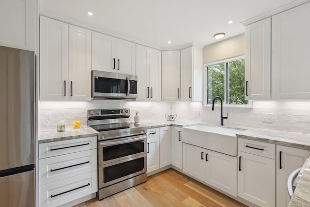 787 Heritage Vlg Unit A, Southbury, CT 06488 - kitchen with appliances with stainless steel finishes, a sink, white cabinets, decorative backsplash, and recessed lighting